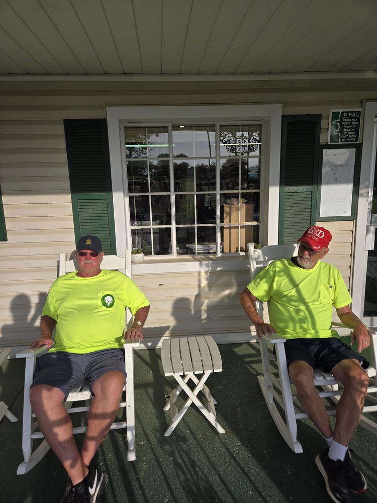 2 men wearing yellow shirts, sitting on rocking chairs