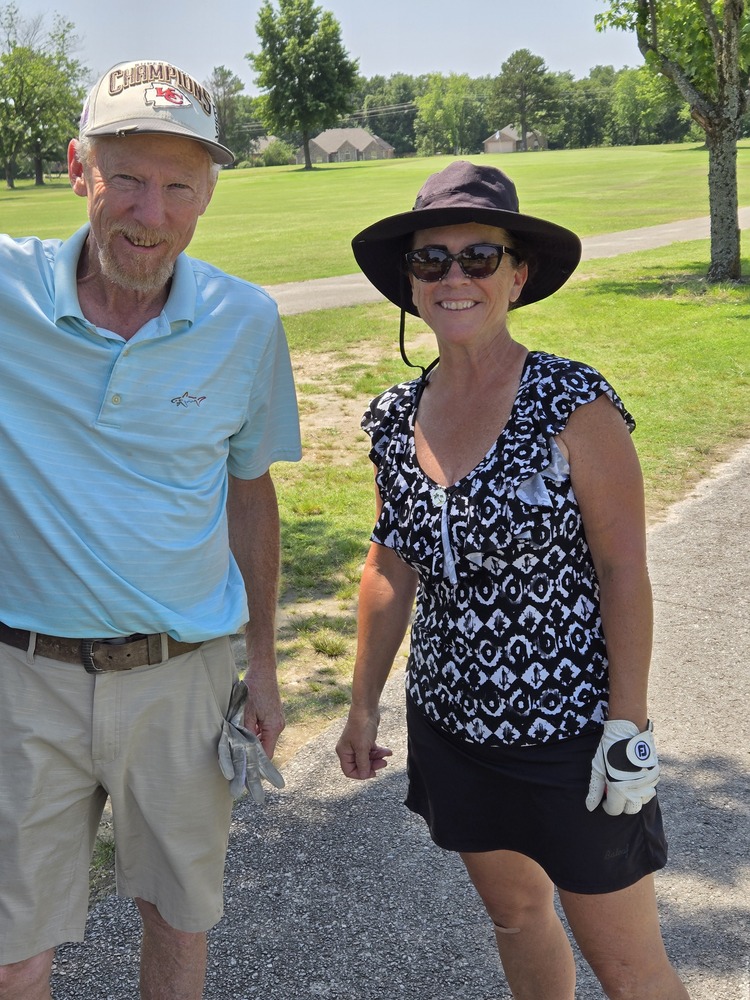 Man and Woman standing on golf course.