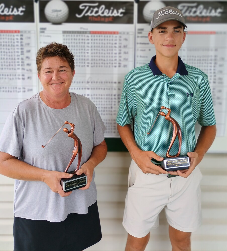 A woman and young man holding trophies