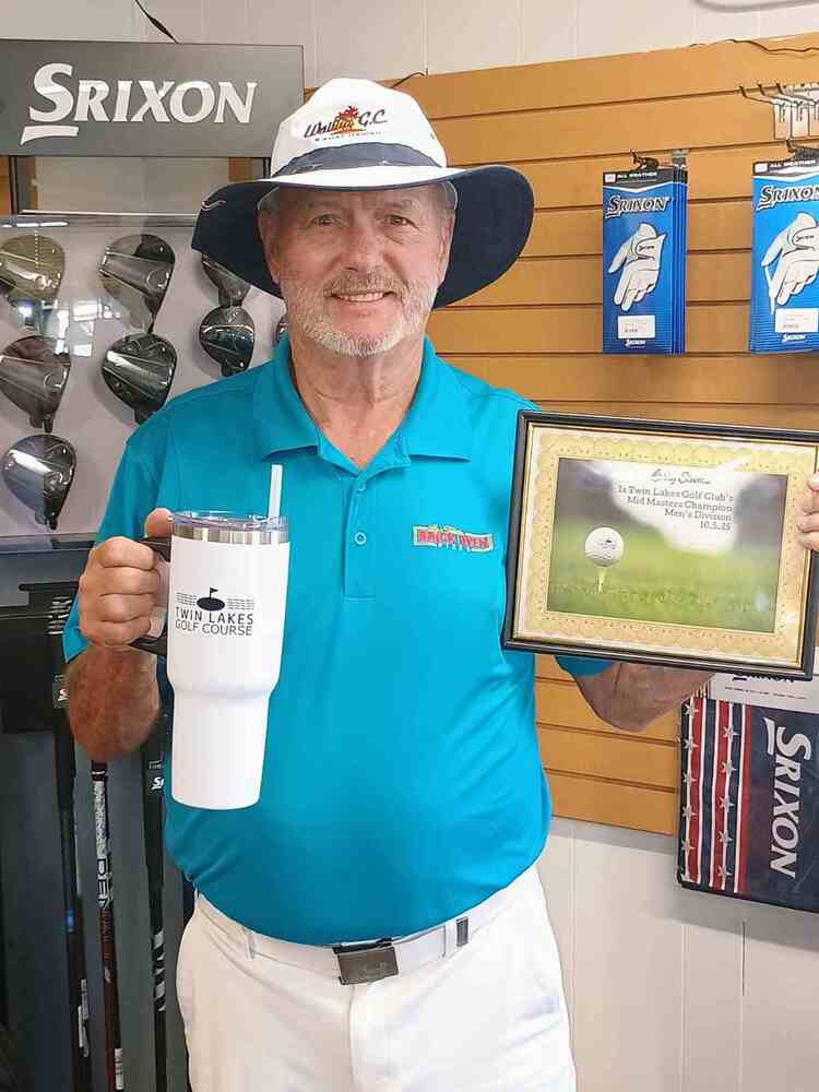 Man in golf shop holding certificate and thermal mug