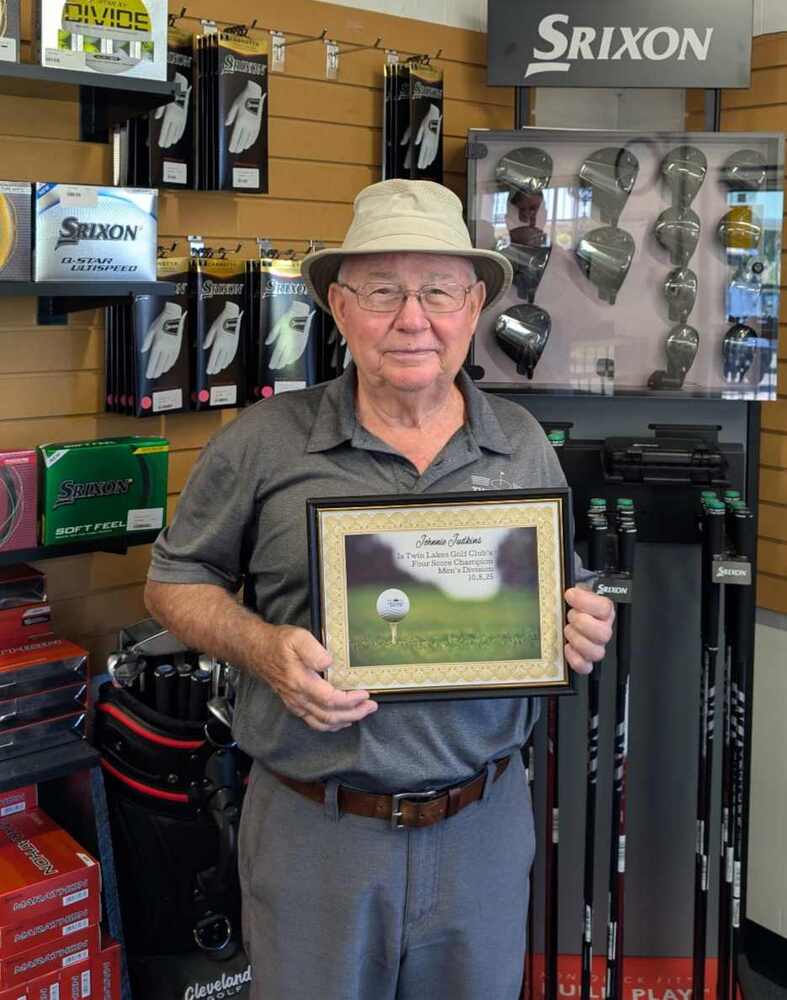 Elder man wearing a hat in golf shop holding a certificate
